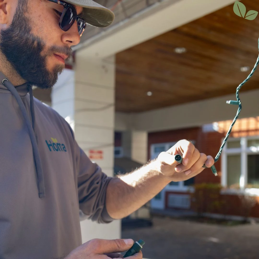 Technician installing Christmas lights at a senior living residence