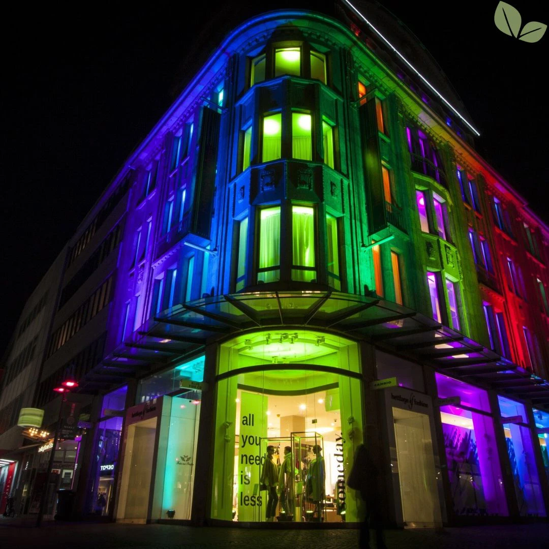 Commercial architectural lighting illuminating a multi-story retail building exterior with colorful LED facade lights at night
