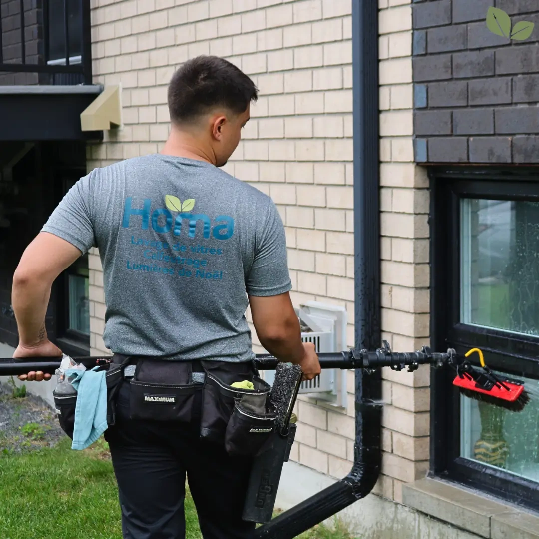 Homa technician cleaning commercial building windows using a water-fed pole system