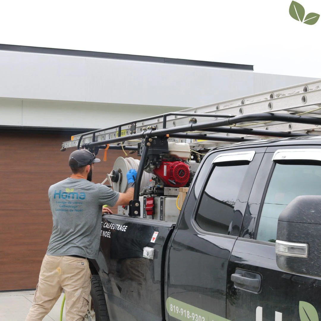 Technician preparing pressure washing equipment on Homa service truck