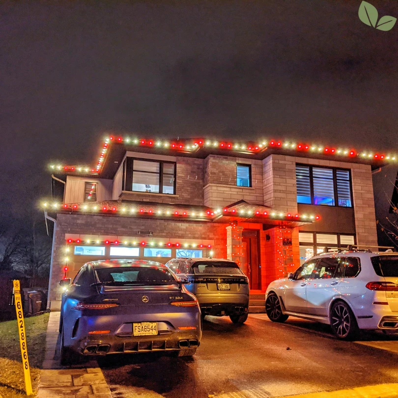 Residential home decorated with professionally installed holiday exterior lighting by Homa at night