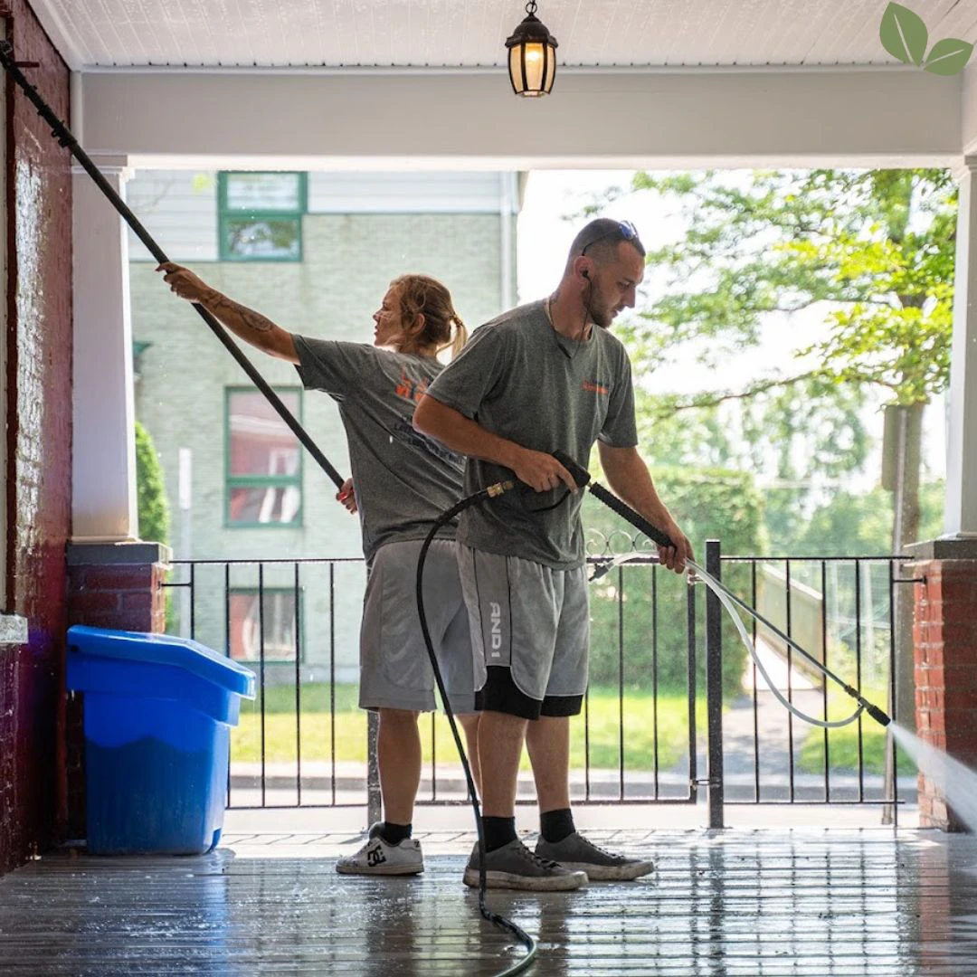 Technicians pressure washing residential porch and exterior surfaces