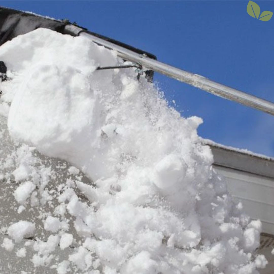 Close-up of snow being removed from a residential roof edge using a roof rake to prevent ice dams