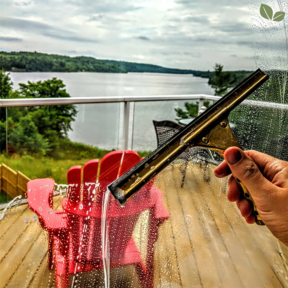 Homa technician hand-cleaning residential balcony windows using a professional squeegee